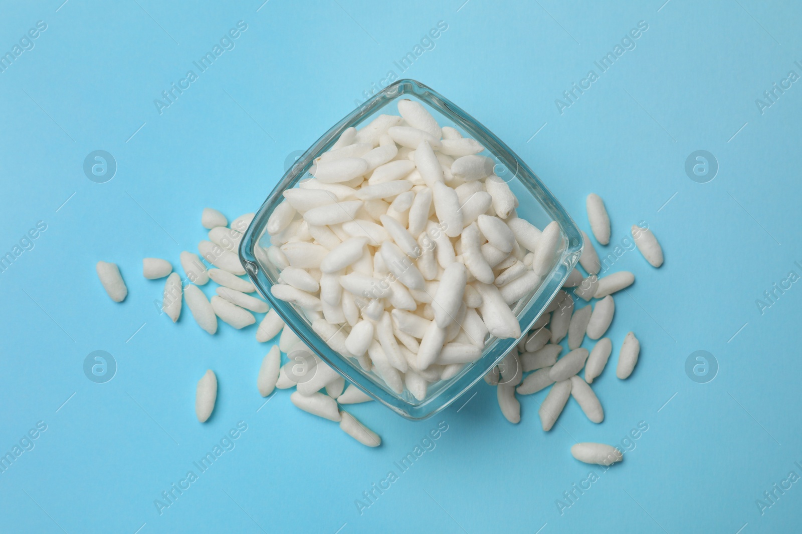 Photo of Puffed rice in bowl on light blue background, top view