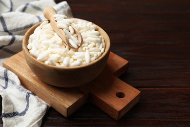 Photo of Puffed rice in bowl and scoop on wooden table, closeup