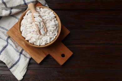 Photo of Puffed rice in bowl and scoop on wooden table, top view. Space for text