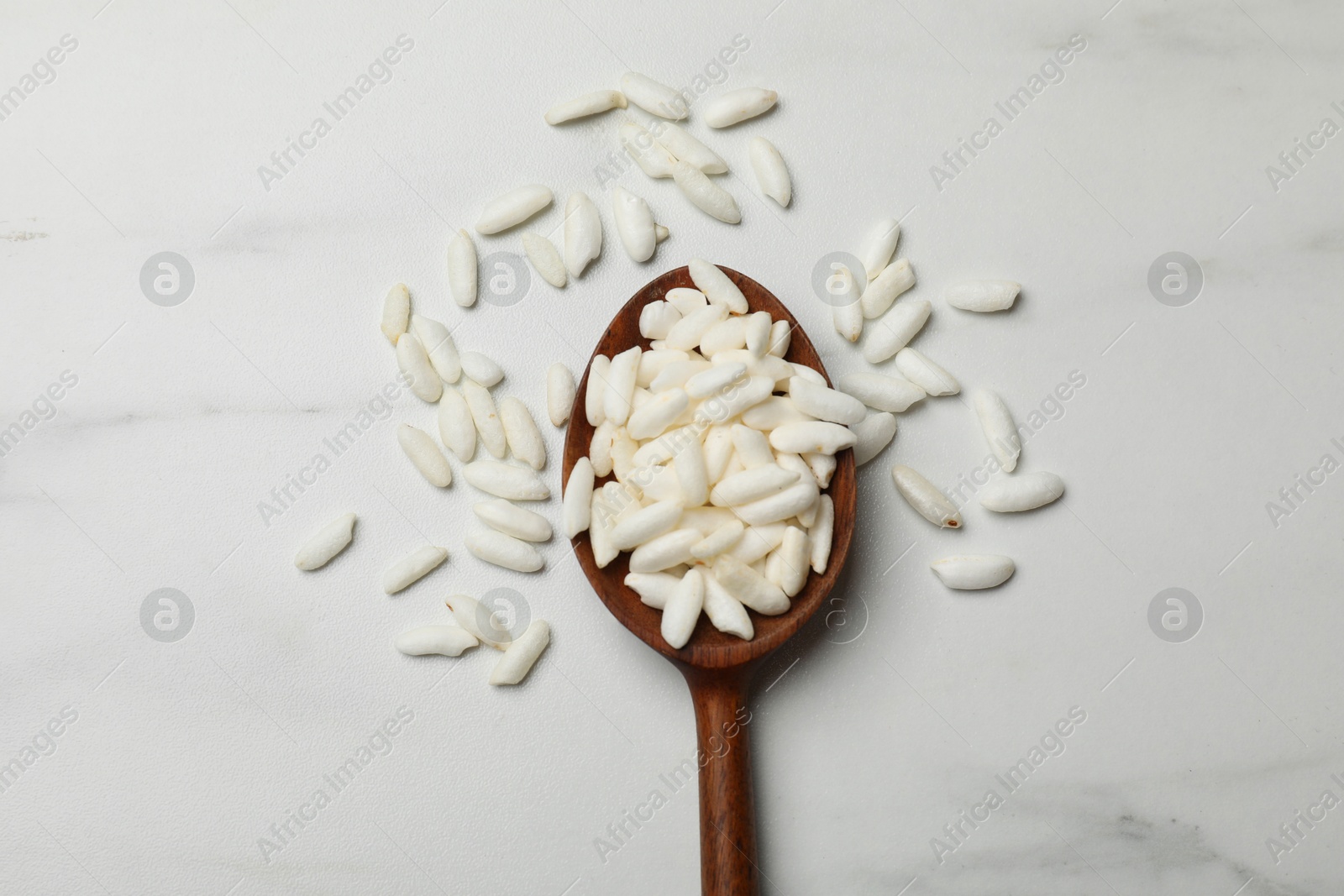 Photo of Spoon with puffed rice on white table, top view