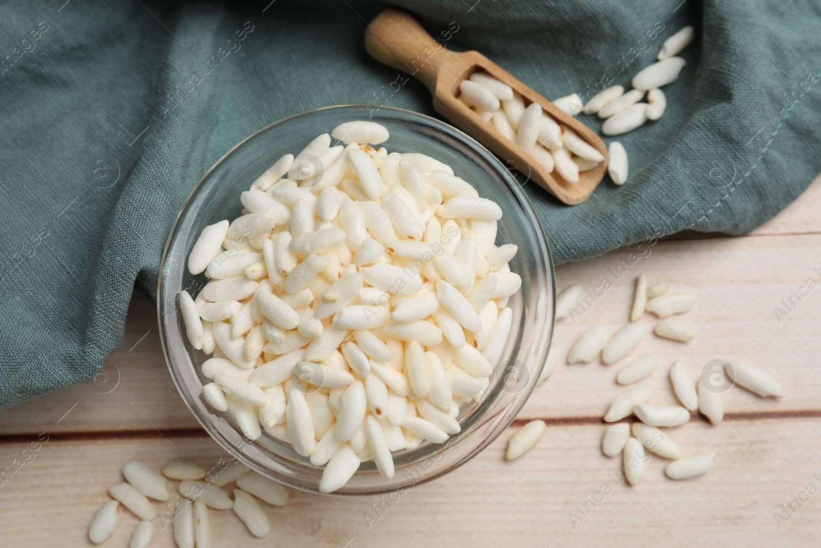 Photo of Puffed rice in bowl and scoop on white wooden table, flat lay