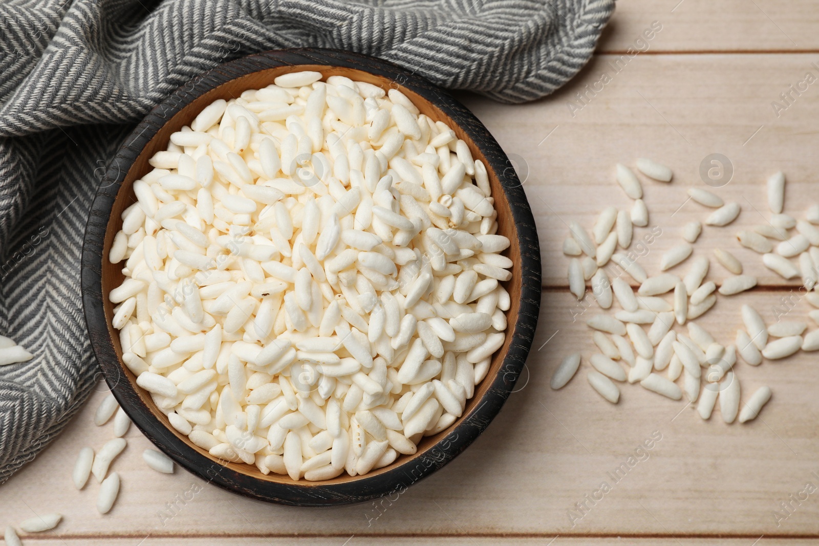 Photo of Puffed rice in bowl on white wooden table, flat lay