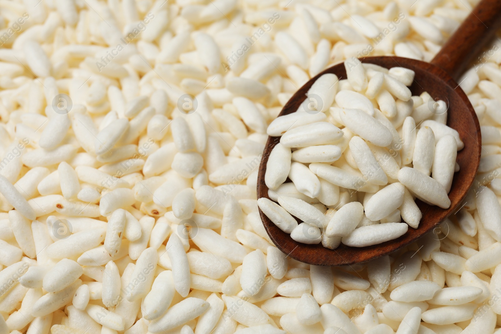 Photo of Wholegrain puffed rice and wooden spoon, closeup