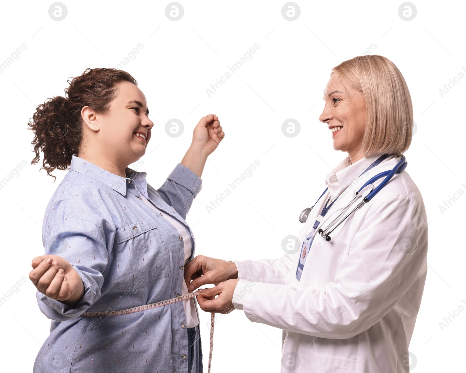 Photo of Happy woman lost weight. Smiling nutritionist measuring patient's waist with tape on white background