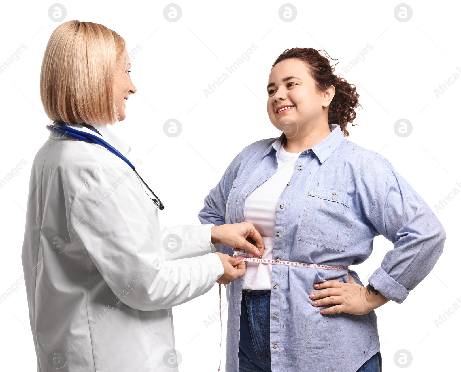 Photo of Happy woman lost weight. Nutritionist measuring patient's waist with tape on white background