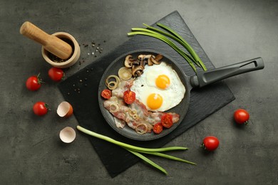 Photo of Tasty fried eggs, bacon and mushrooms served on grey table, flat lay