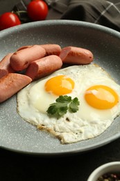 Photo of Tasty fried eggs and sausages served on table, closeup