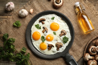 Photo of Tasty fried eggs with mushrooms and parsley served on wooden table, flat lay