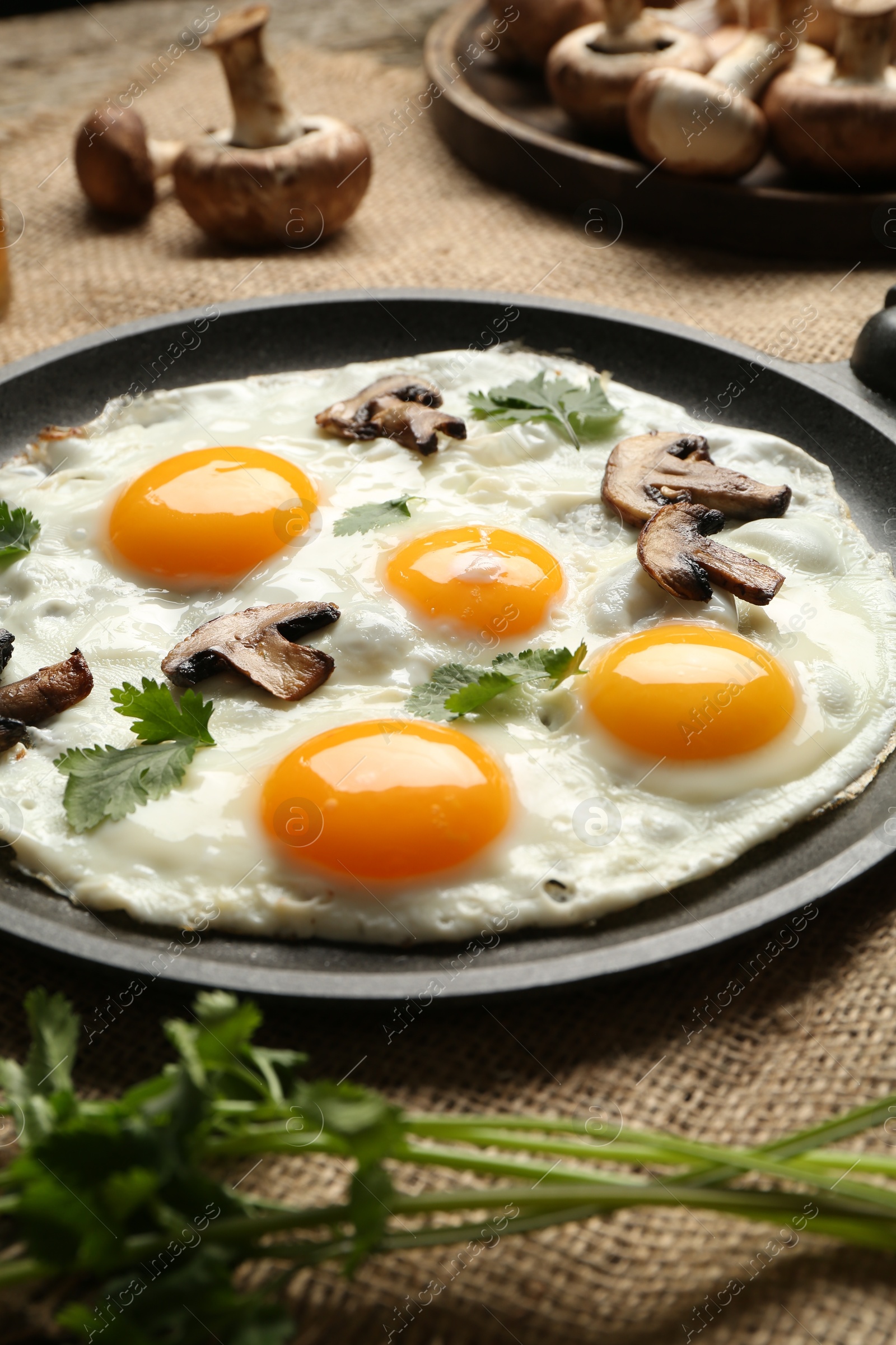 Photo of Tasty fried eggs with mushrooms and parsley served on table, closeup