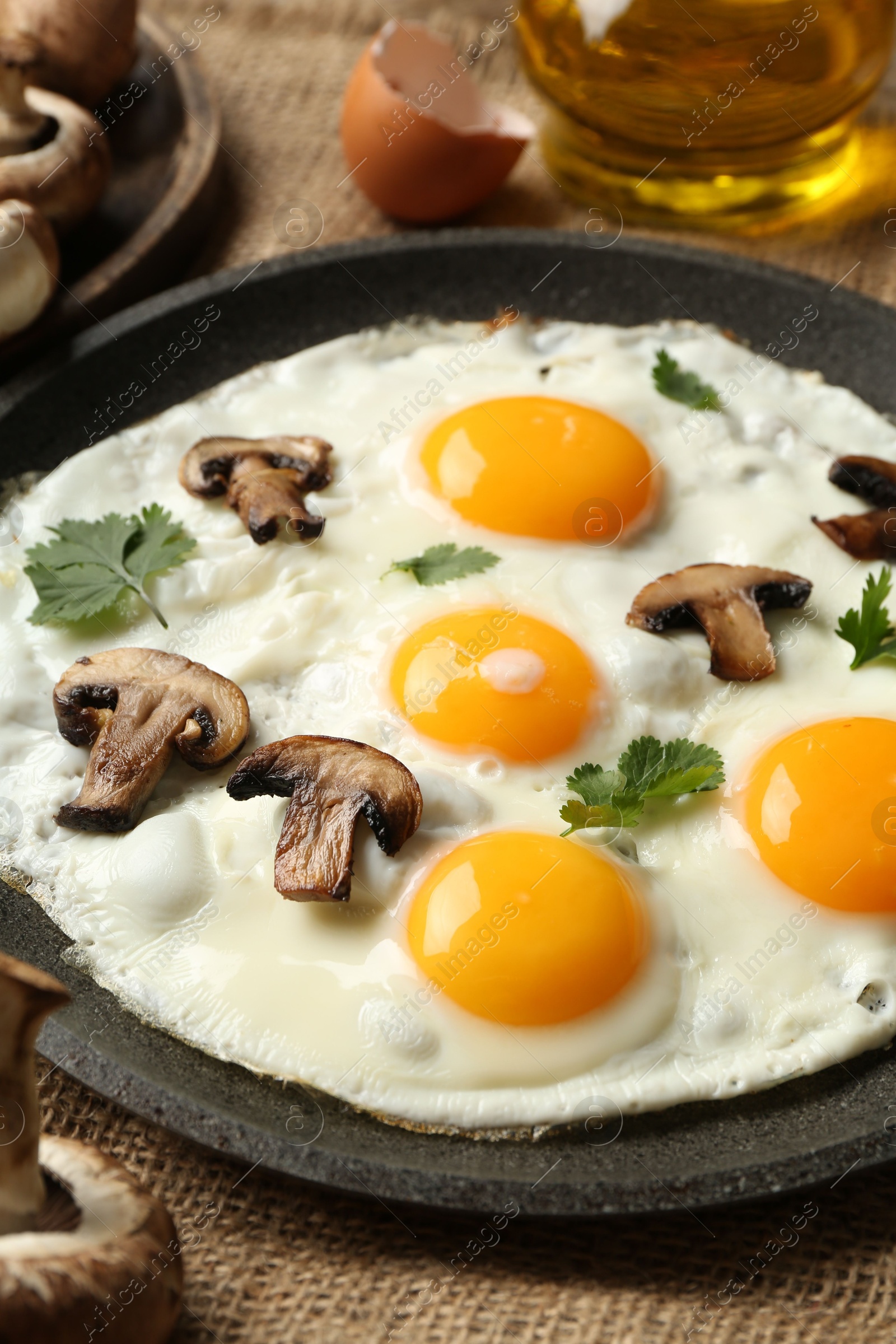 Photo of Tasty fried eggs with mushrooms and parsley served on table, closeup