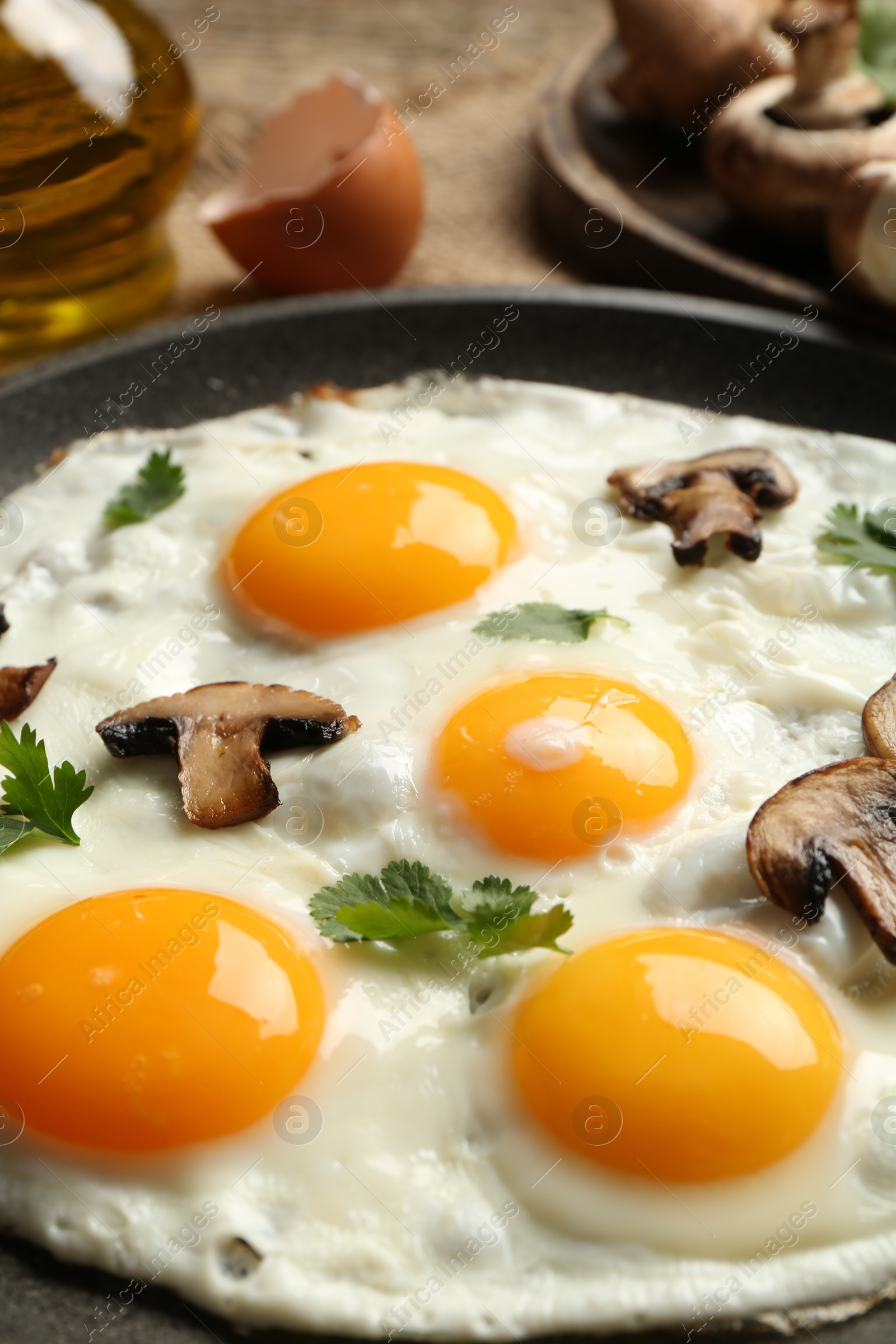 Photo of Tasty fried eggs with mushrooms and parsley served on table, closeup