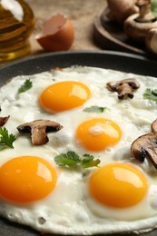 Photo of Tasty fried eggs with mushrooms and parsley served on table, closeup