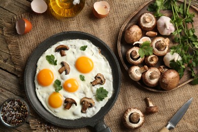 Photo of Tasty fried eggs with mushrooms and parsley served on wooden table, flat lay