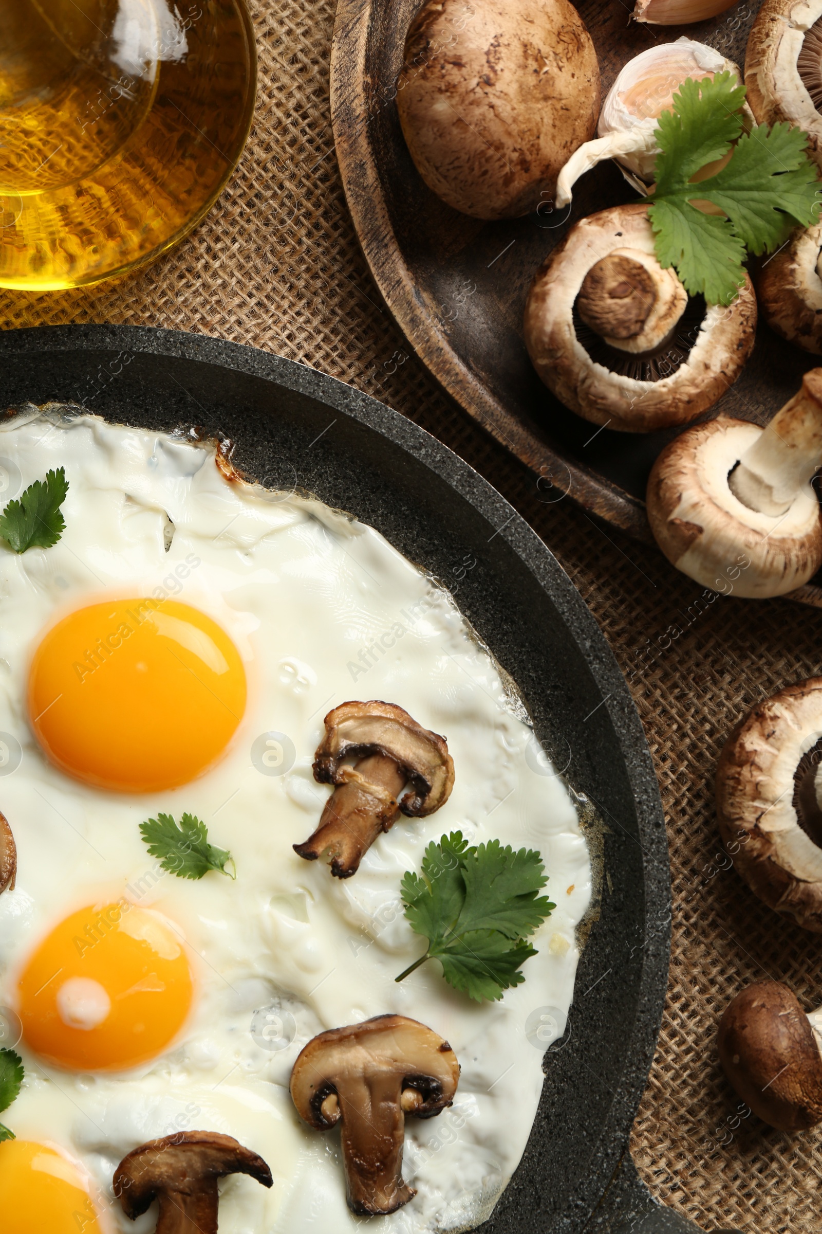 Photo of Tasty fried eggs with mushrooms and parsley served on table, flat lay