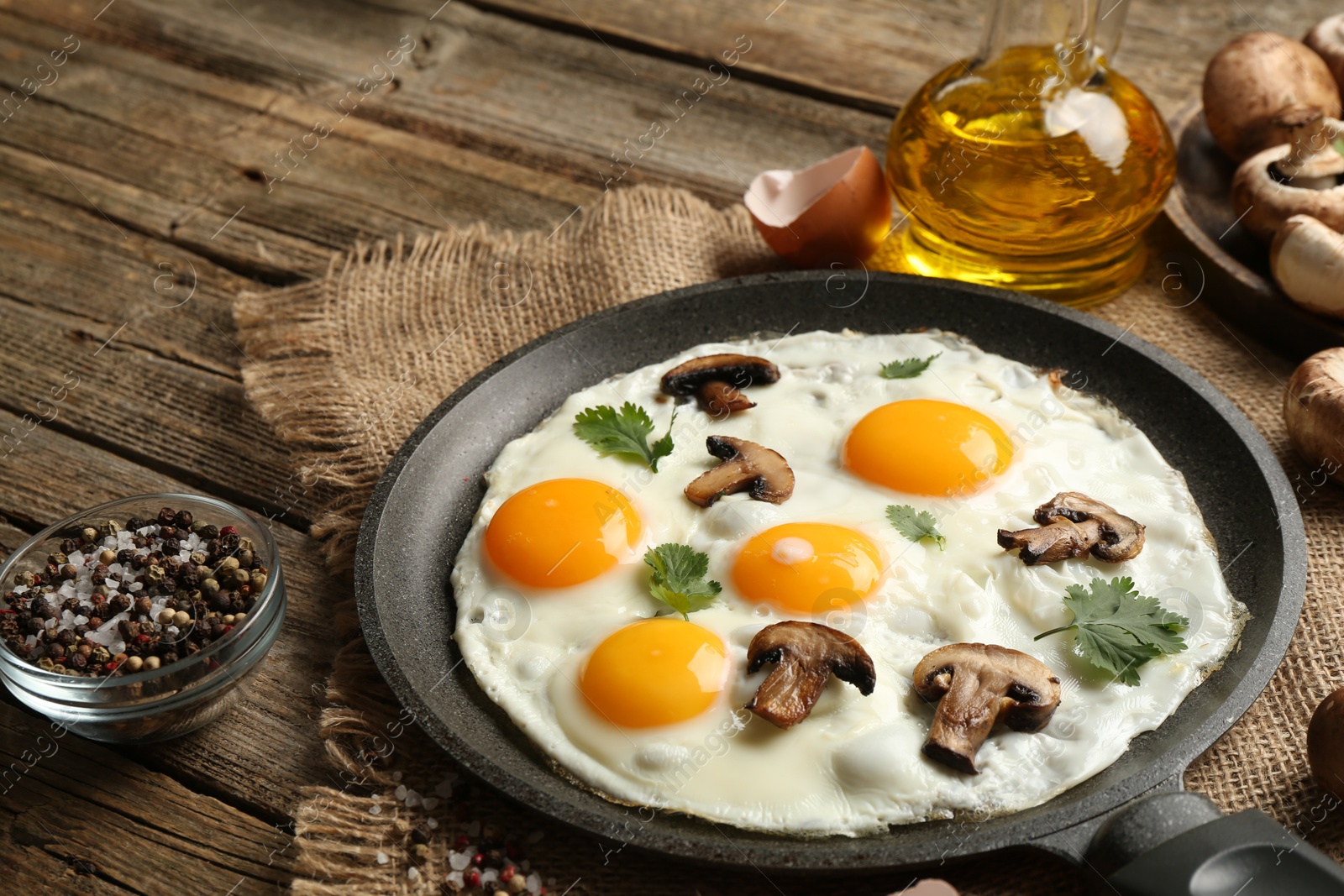 Photo of Tasty fried eggs with mushrooms and parsley served on wooden table, closeup