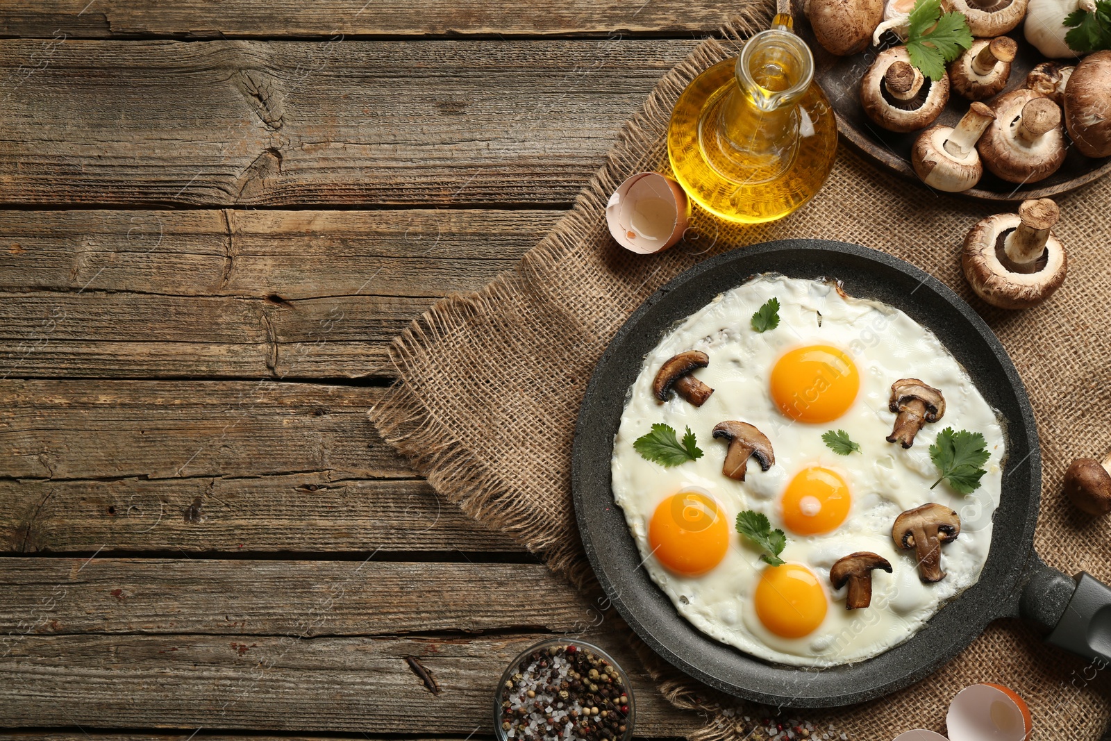 Photo of Tasty fried eggs with mushrooms and parsley served on wooden table, flat lay. Space for text