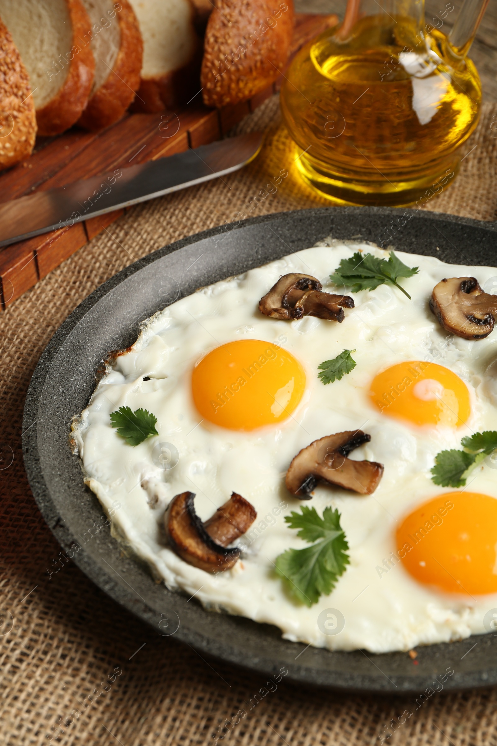 Photo of Tasty fried eggs with mushrooms and parsley served on table, closeup