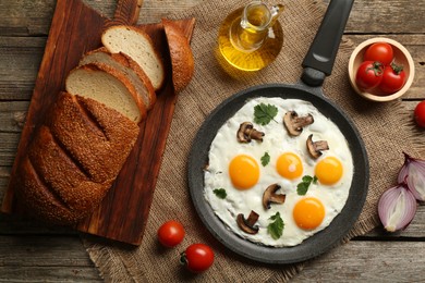 Photo of Tasty fried eggs with mushrooms and parsley served on wooden table, flat lay