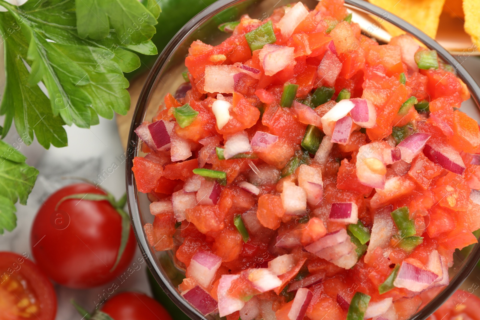 Photo of Delicious salsa in bowl and ingredients on table, top view