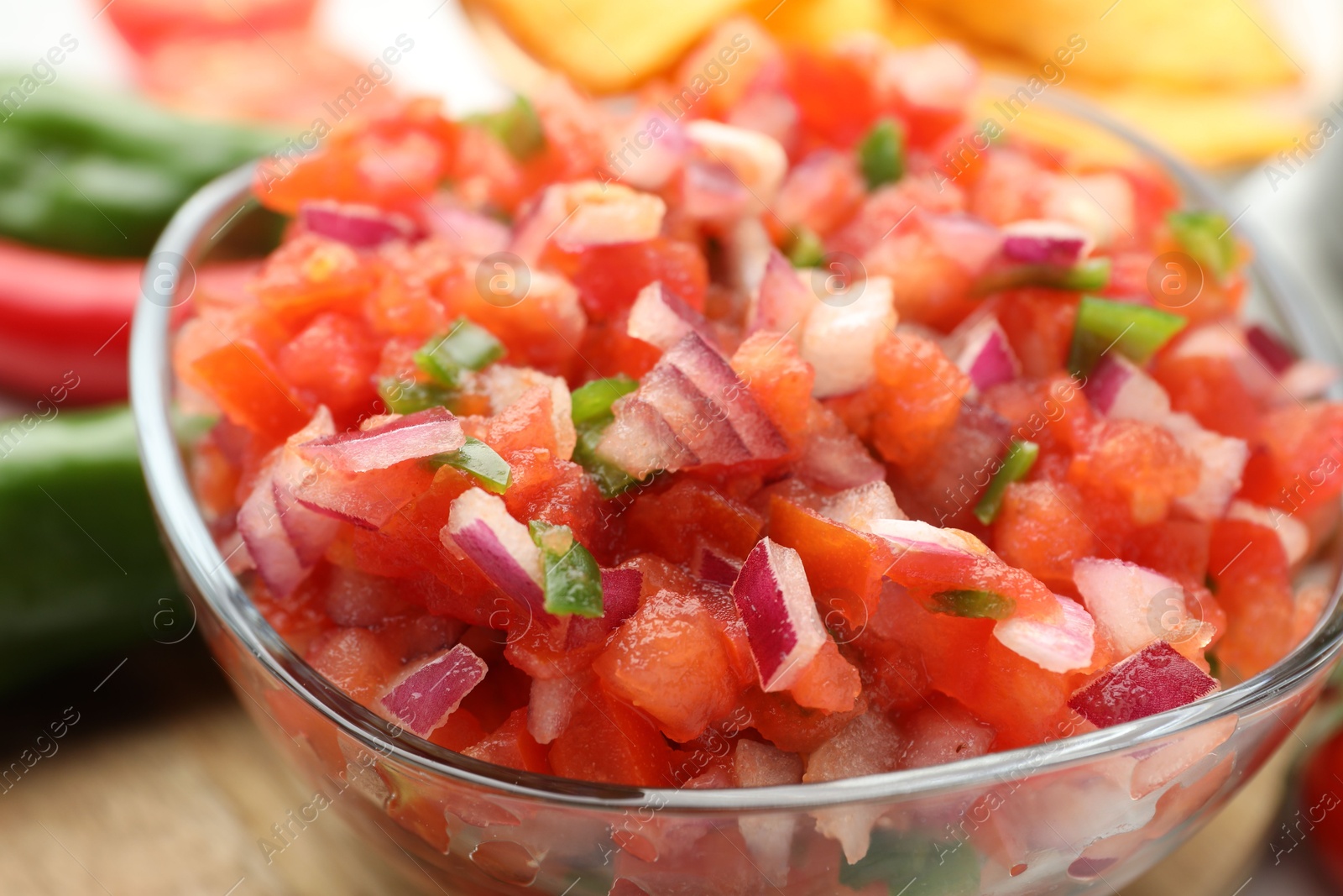 Photo of Delicious salsa in glass bowl on table, closeup