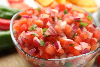 Photo of Delicious salsa in glass bowl on table, closeup