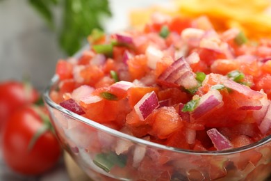 Photo of Delicious salsa in glass bowl on table, closeup