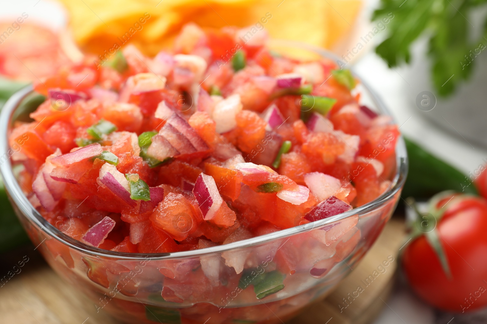 Photo of Delicious salsa in glass bowl on table, closeup