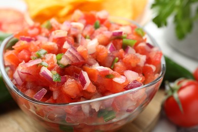 Photo of Delicious salsa in glass bowl on table, closeup