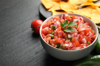 Delicious salsa in bowl on grey table, closeup. Space for text