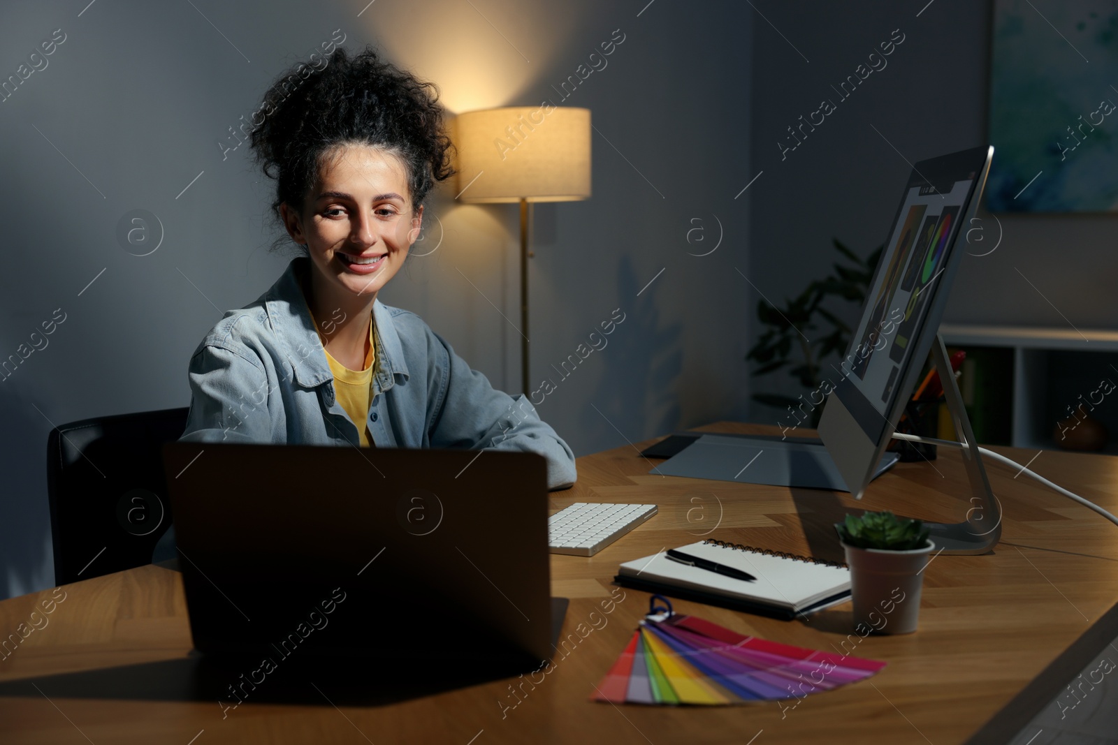 Photo of Designer working on laptop indoors at night