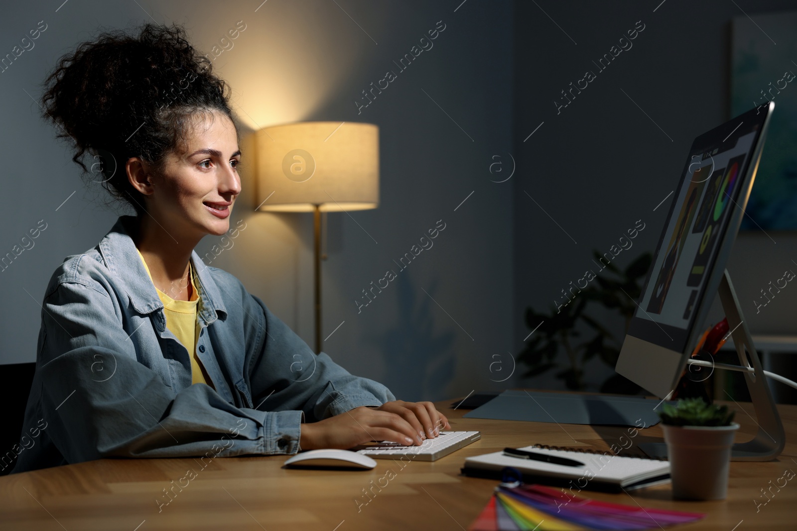 Photo of Designer working on computer indoors at night