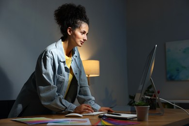 Photo of Designer working on computer indoors at night