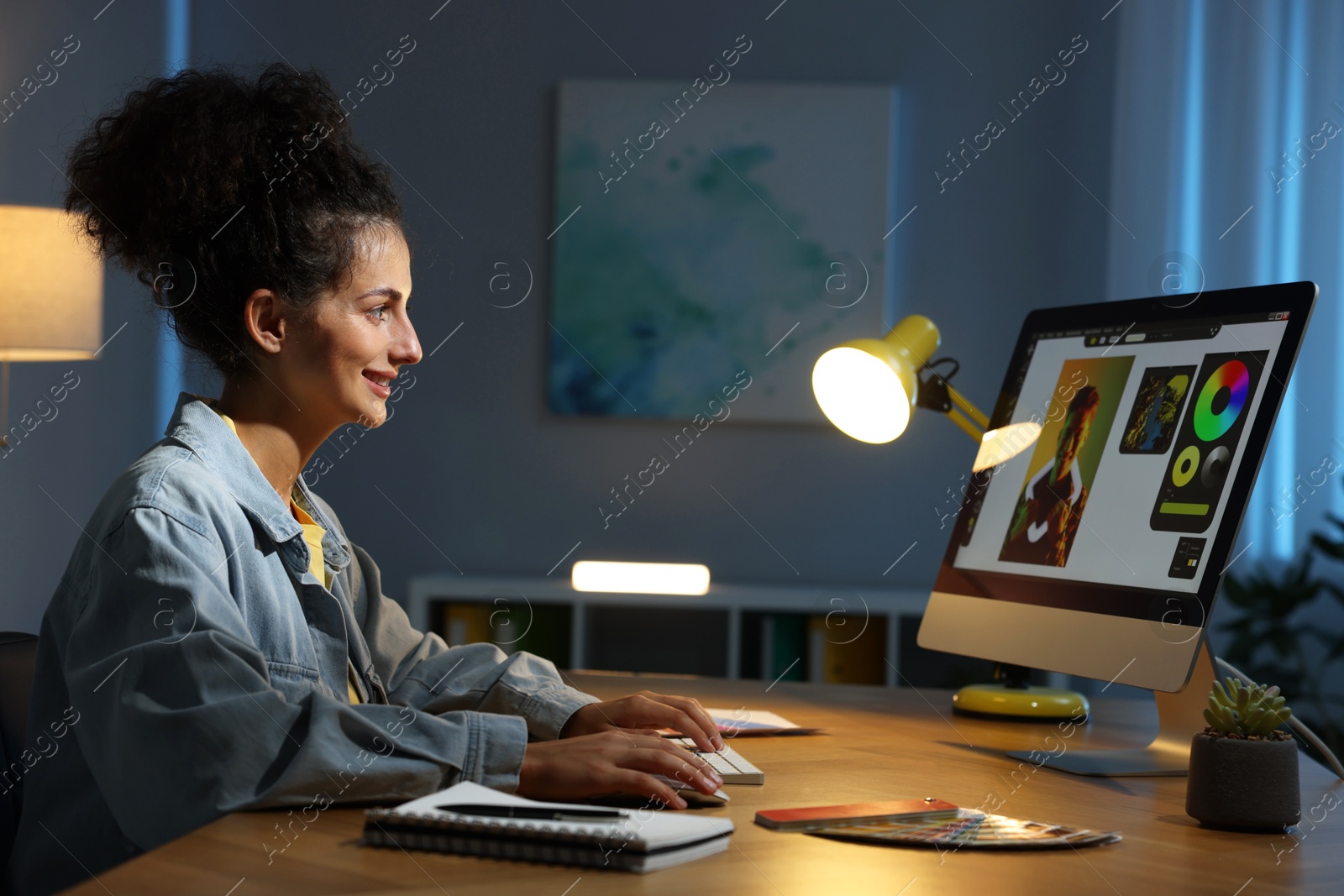 Photo of Designer working on computer indoors at night