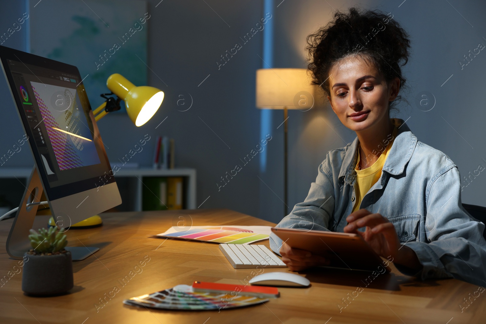 Photo of Designer working on tablet indoors at night