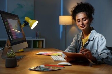 Photo of Designer working on tablet indoors at night