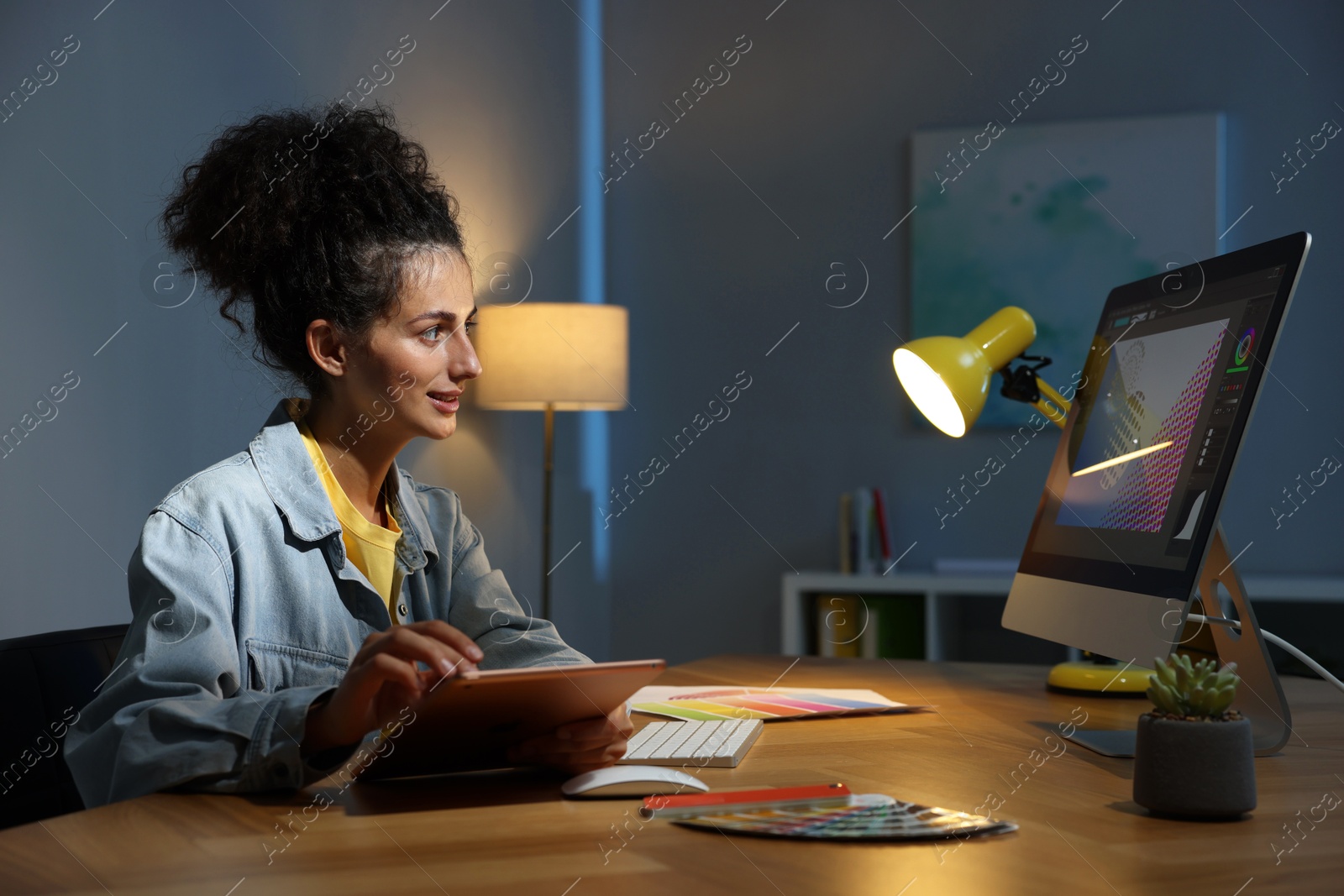 Photo of Designer with tablet working indoors at night