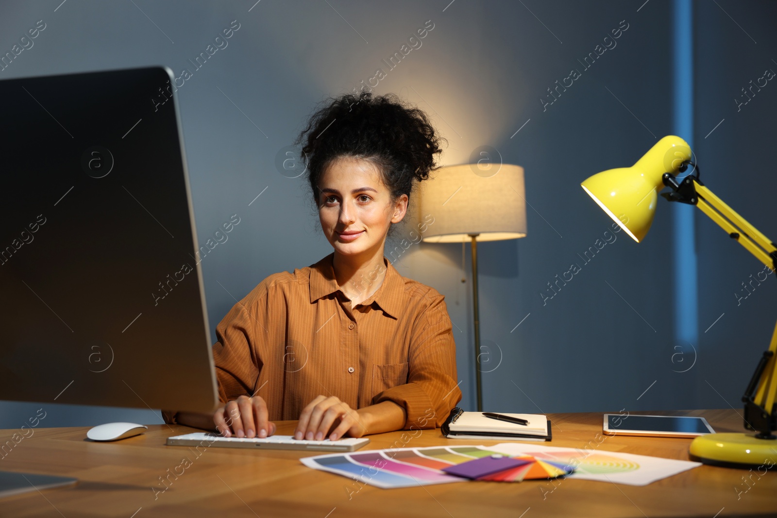 Photo of Designer working on computer indoors at night