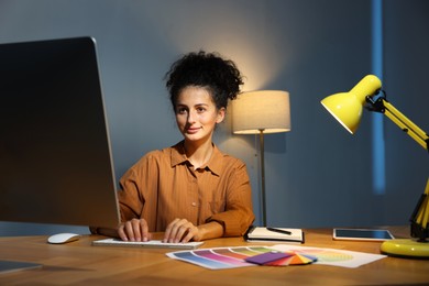 Photo of Designer working on computer indoors at night