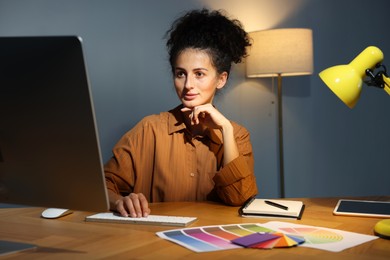 Photo of Designer working on computer indoors at night