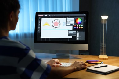 Photo of Designer working on computer indoors at night, closeup