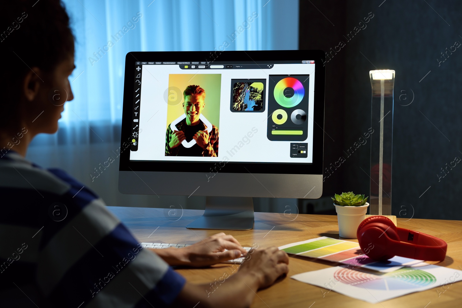 Photo of Designer working on computer indoors at night