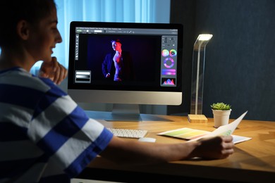 Photo of Designer with color palette working indoors at night