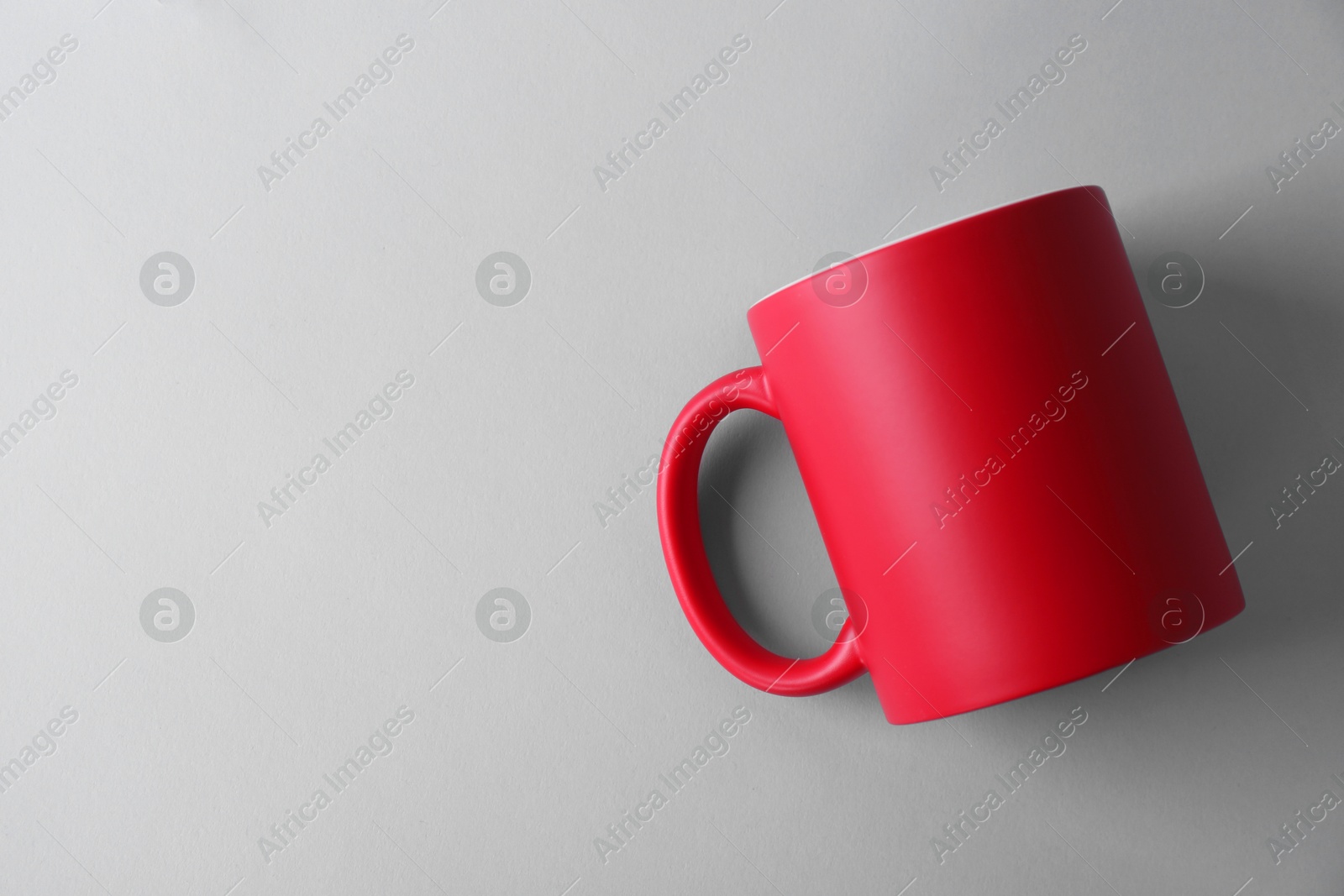 Photo of One blank red mug on light background, top view. Mockup for design