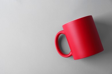 Photo of One blank red mug on light background, top view. Mockup for design