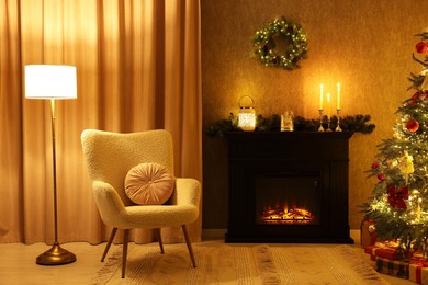 Photo of Fireplace, armchair, Christmas tree and festive decor in cozy room