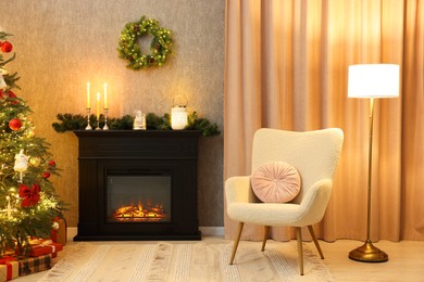 Photo of Fireplace, armchair, Christmas tree and festive decor in cozy room