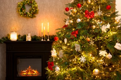 Photo of Beautifully decorated Christmas tree, fireplace and festive decor in room