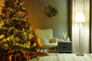 Cozy room with beautiful Christmas tree, armchair and lamp. Interior design for holiday