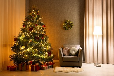 Cozy room with beautiful Christmas tree, armchair and lamp. Interior design for holiday