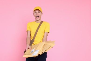 Photo of Happy postman with bag and envelopes on pink background. Space for text